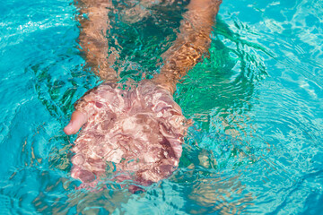 Male hands cupped together submerged in clean clear blue water