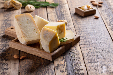 Various types of cheese on tray on wooden table. Cheese plate. Copy space.