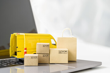 Fast parcel delivery, e-commerce service concept : Delivery van, shopping bag, boxes on a laptop,...