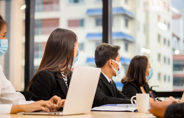 Success and Teamwork Concepts, Group of young business people have a meeting in the office while wear mask as protection from corona virus