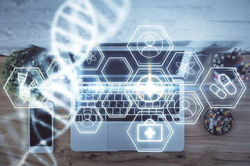 DNA hologram drawings over computer on the desktop background. Top view. Multi exposure. Concept medical education.