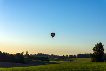 Silhouette hot air balloon in blue sky landscape background.Hot air balloon over the green field.