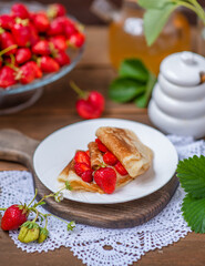 Thin pancakes stacked with strawberries between layers