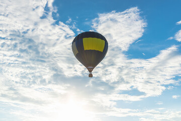 Hot Air Balloon and blue sky white cloud.Blue yellow hot air balloon in the air at summer evening.