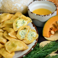 Boiled pumpkin dumplings with egg and dill filling, cross section. Convenience Food. Square format. Soft focus. Close-up shot.