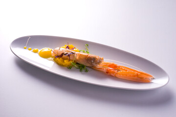 dish with marinated scampi and mango mousse. white background