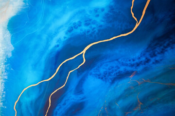 Part of original resin art epoxy resin painting. High quality details. Marble texture. Fluid art for modern banners, ethereal graphic design. Abstract ethereal bronze, blue and white swirl.