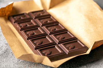 Pieces of brown chocolate dark background. Candy sweet dessert and snack. Dark chocolate is...