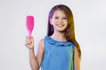 cute little child girl holding hair comb on white background