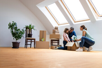 Young caucasian family moving into new house and unpacking boxes together.