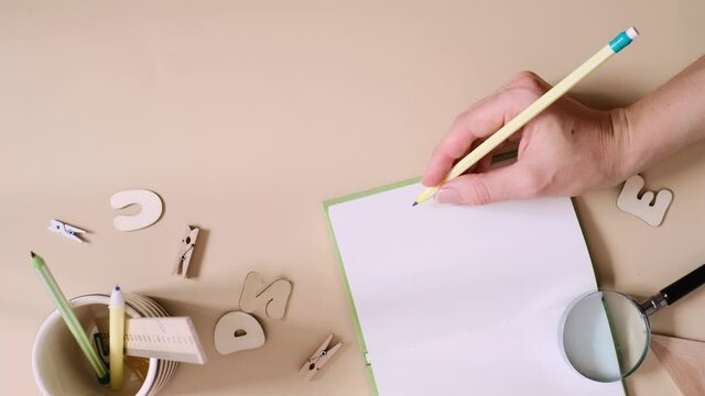 Top view of woman writing in blank notebook with pencil, having new ideas concept. Copy space. Vertical video frame 9x16