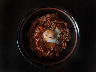 beef bulgogi with kimchi and egg on rice on dish
