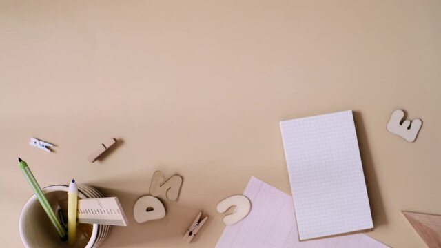 Search idea concept. Person searching with magnifying glass in the notebook with school supplies on the beige background. Flat Lay. Vertical video frame 9x16