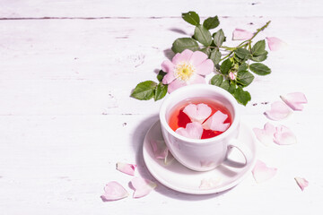 Obraz na płótnie Canvas Tea from rose hips flowers, vitamin drink, hard light, dark shadow