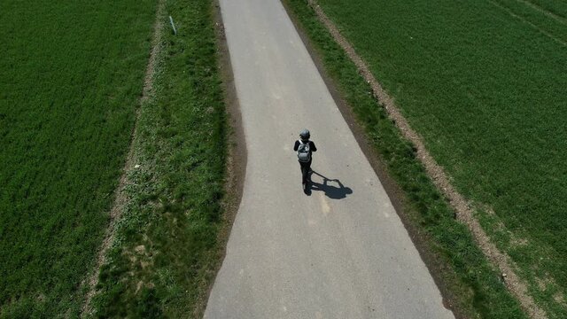 Riding a scooter outside the city between the fields