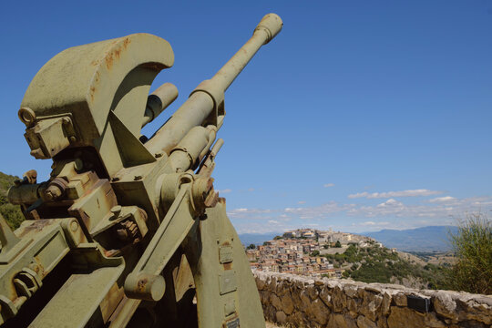 The ancient Sant'Oreste hamlet on the background with a world war two anti aircraft cannon in foreground near Monte Soratte fallout shelter, Sant'Oreste, Rome, Italy 