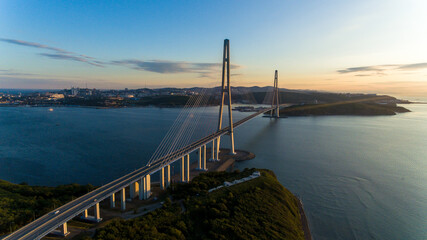 Russian bridge across the Eastern Bosphorus Strait in Vladivostok. View from above. Russian bridge against the background of a beautiful sunrise.