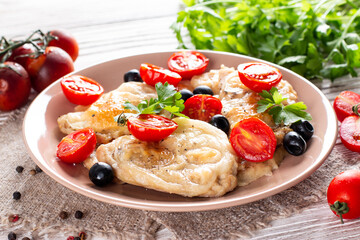 Fried chicken chop. Home fried chicken chop with tomatoes, olives and cheese on a wooden table. Rustic style.
