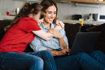 Woman and her daughter with down syndrome using laptop