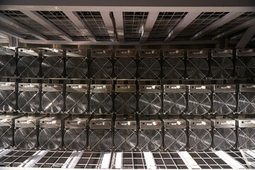 Bitcoin ASIC miners in warehouse. ASIC mining equipment on stand racks for mining cryptocurrency in...