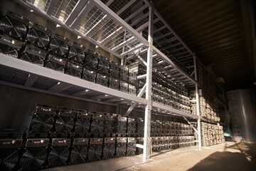 Bitcoin ASIC miners in warehouse. ASIC mining equipment on stand racks for mining cryptocurrency in...