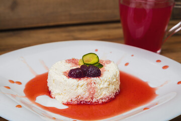 Morning breakfast cottage cheese with jam in a white plate with a cup of jelly. Close-up.
