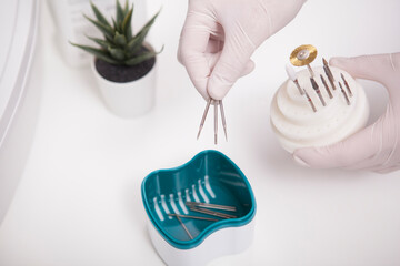 Cropped close up of manicurist putting nail drill bits insto sterilizer