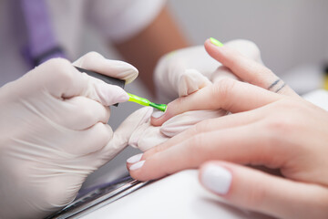 Close up of manicurist doing neon nails