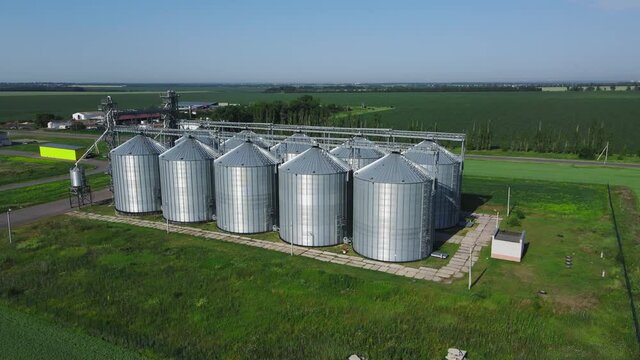 Top of grain elevators. Modern silver granaries for grain storing and processing. Exterior of aluminum containers at sunlight. View from the air.