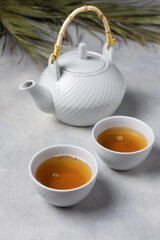 Asian tea ceremony. Teapot and tea cups with tea drink on table.