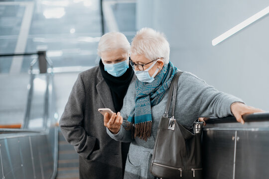 two female tourists standing on the escalator in the subway. - Powered by Adobe