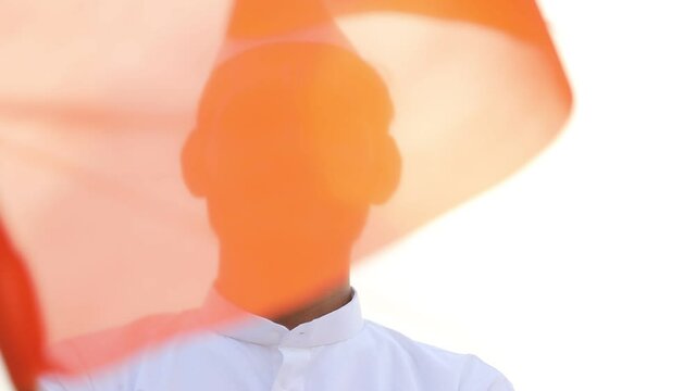 Young indian man (pilgrim) in traditional wear and waving religious flag.