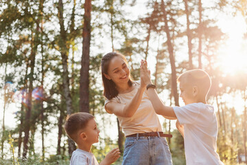 Portrait of happy family posing outdoor. other with kids spending time in forest in sunset, mommy...
