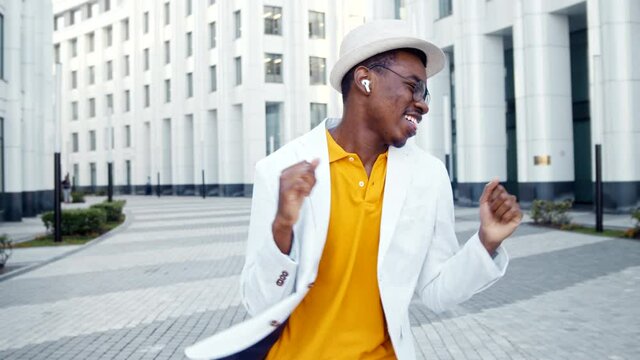 Amazed guy in yellow t shirt and white suit dances and sings