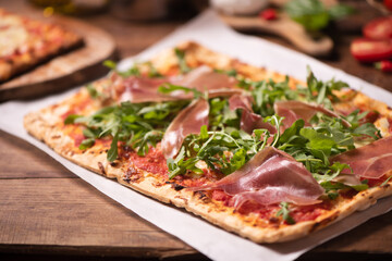 Italian Focaccia with rucola rocket arugula on rustic table.