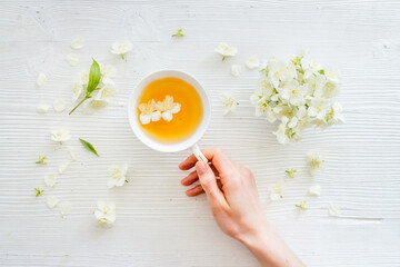Tea in a cup with jasmine flowers. Herbal tea top view