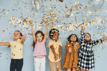 Balloons and confetti. Children on celebrating birthday party indoors have fun together