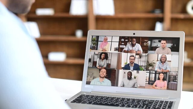 Intelligent clever indian male office employee making video call, talking ia video connect on the laptop, eastern man in smart casual shirt holding negotiation, discussion with group of diverse people