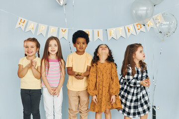 Children on celebrating birthday party indoors have fun together