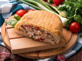 Shawarma with chicken in bread, vegetables and French fries on a wooden table.