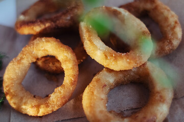 Close-up of onion rings in batter. Fried vegetables at a fast food restaurant. Vegetarian cuisine in a cafe. Meal for those who do not eat meat