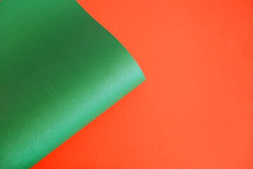 Green cardboard on an orange background. The texture of the cardboard.