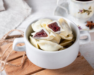 Sweet dumplings with chocolate in a cherry inside, in the section, close-up.White wooden background. Sweet dumplings.