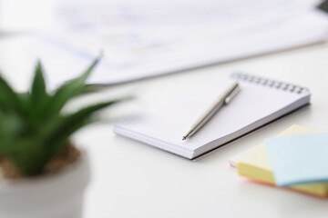 Blank notebook with pen and colored stickers lies on table clloseup