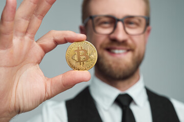 Happy businessman showing bitcoin coin