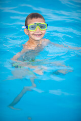 Naklejka premium Cute little boy in a swimming pool