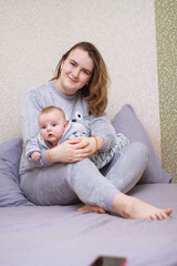 home photos of a young mother with a small child. Newborn boy. Cute, cozy photos with a baby.