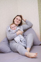 Obraz premium home photos of a young mother with a small child. Newborn boy. Cute, cozy photos with a baby.