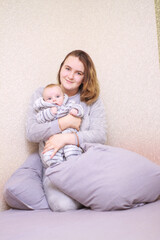 home photos of a young mother with a small child. Newborn boy. Cute, cozy photos with a baby.