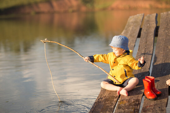 Little Boy Catching a Fish from wooden dock